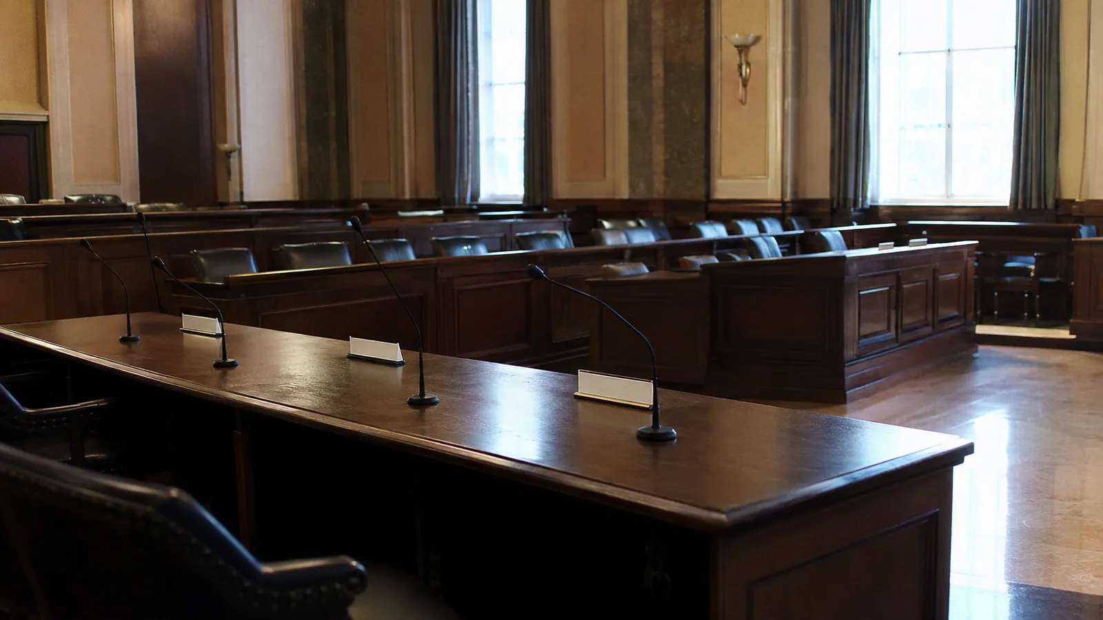 A hearing room awaiting deliberation — name plates turned face down