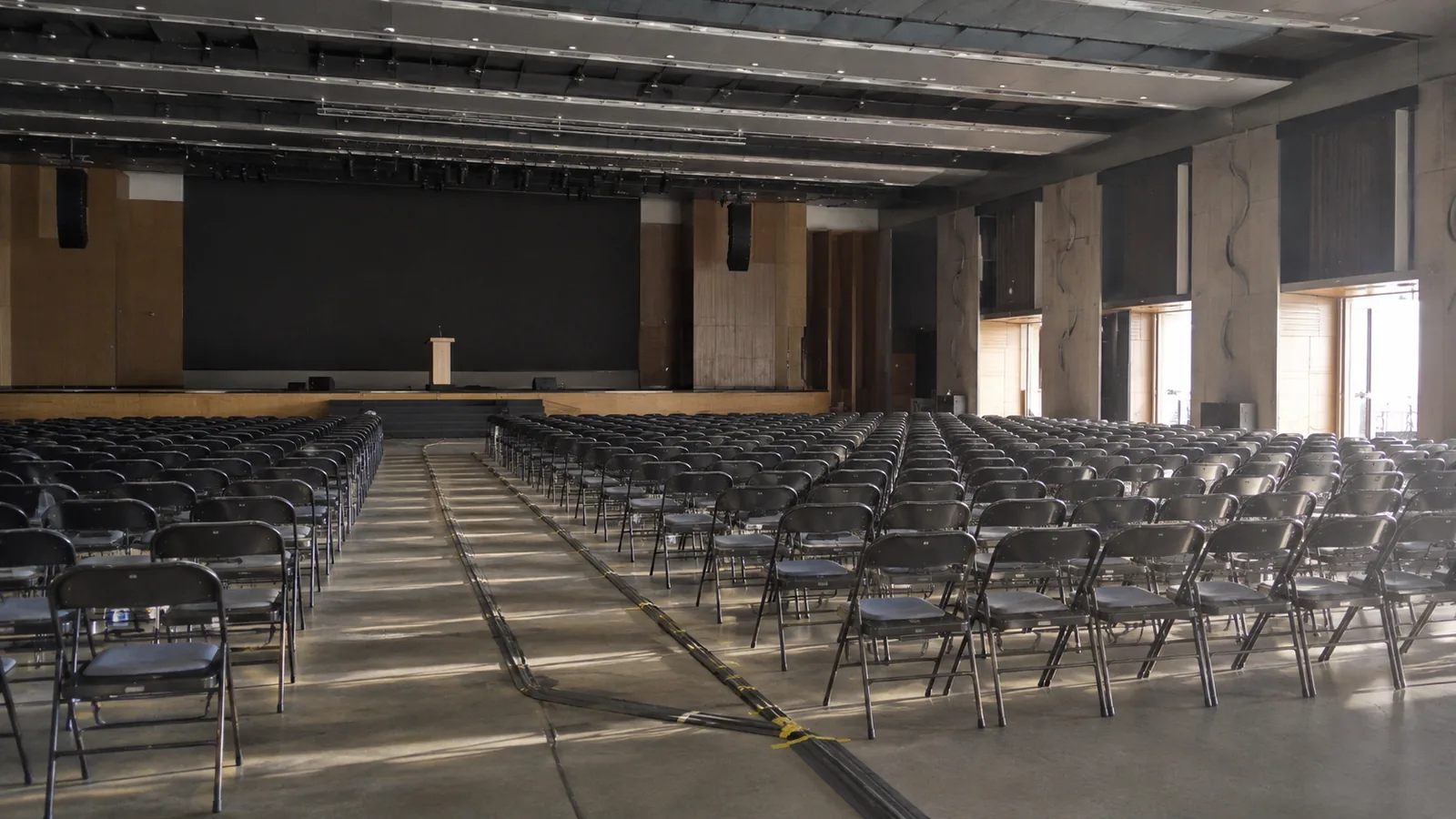 A convention hall before the event — folding chairs facing an empty podium